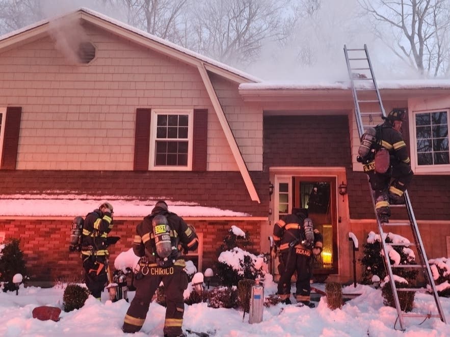 Danbury firefighters on Tuesday, Jan. 20, tend to the scene of a house fire on Richter Drive.