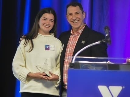 Elizabeth Thibault, left, received the inaugural Mission Impact Staff Award during the YMCA of Greater Hartford’s 174th annual meeting. At right is Camp Woodstock Executive Director Tony Gronski, where Thibault worked.
