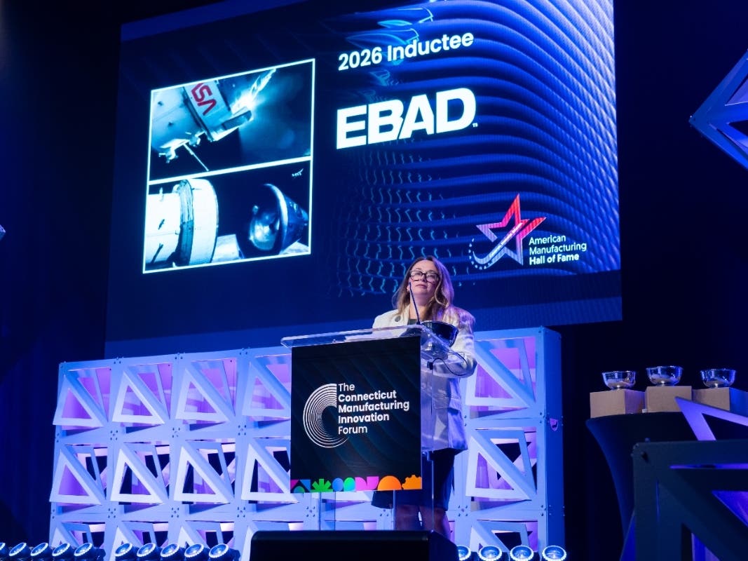 Lisa Brown, market segment director for launch vehicles at EBAD in Simsbury, accepts the honor on behalf of the company at the 2026 Connecticut Manufacturing Innovation Forum.