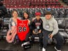 Amber Costa receives a custom jersey as she watches warmups courtside with her family. 