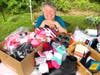 Cynthia Greb, the president of Arrows, surrounded by donated shoes and socks for the Lakota.