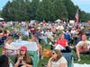The crowd listens to a patriotic band concert by the Riverside Symphonia.
