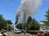 Smoke rises into the sky as firefighters arrive on the scene.