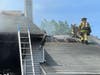 Firefighters open up the roof to vent the fire.