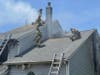 Firefighters open up the roof to vent the fire.
