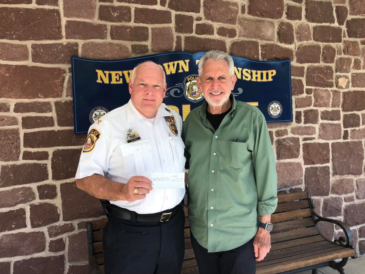 Chief John Hearn accepts a donation from Gene Epstein in support of Shop With A Cop.