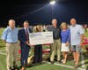 Superintendent Abram Lucabaugh and board president Dana Hunter accept the final check from members of the Stadium Committee including Bruce McKissock, Bill Boger and Wendy and Jon Schneider.