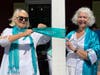 Former Doylestown Borough Councilwoman Joan Doyle, right, and Jane MacNeil, president of Turn the Towns Teal, tie a ribbon on one of the posts in front of Starbucks.