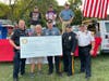 Members of the Newtown Borough and Newtown Township police departments accept the Shop With A Cop donation.