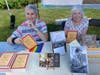 Linda Freed, right, and Elyse Fox share the history of the Plumstead Friends Meeting with Peace Fair visitors. 