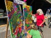 Claire Donahue and her granddaughter, Jordan Pasternak add to the Peace Fair mural.