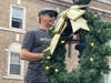Derek John, co-chair of the Discover Doylestown Winterfest Committee, hangs one of the wreaths.
