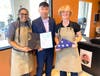 Chef Magali and Isabelle accept a flag flown over the U.S. Capitol from a representative from Congressman Brian Fitzpatrick's office.
