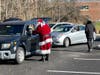 Santa Claus and Gene Epstein go car to car giving out crisp new $100 bills during food distribution event in Bristol Township.