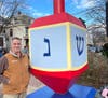 Noel Weiss, president of MBG/McBrick Building Group, next to the refurbished dreidel.