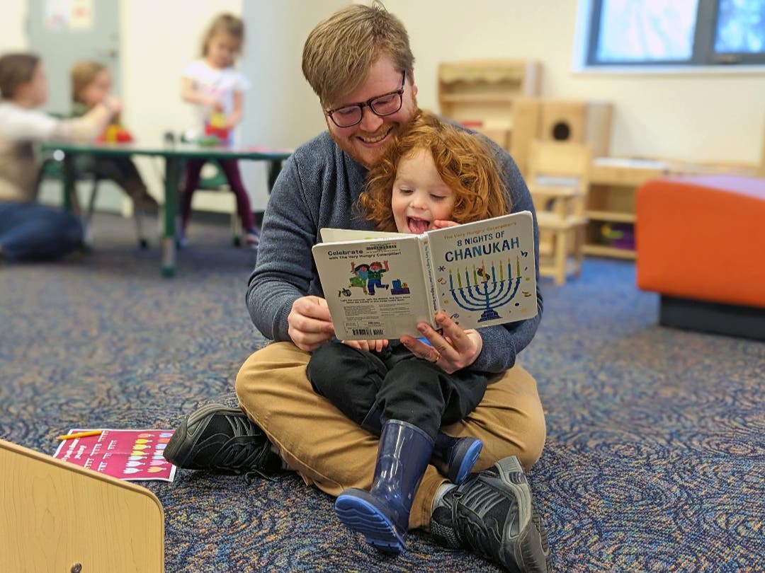 Father and son read a book together.