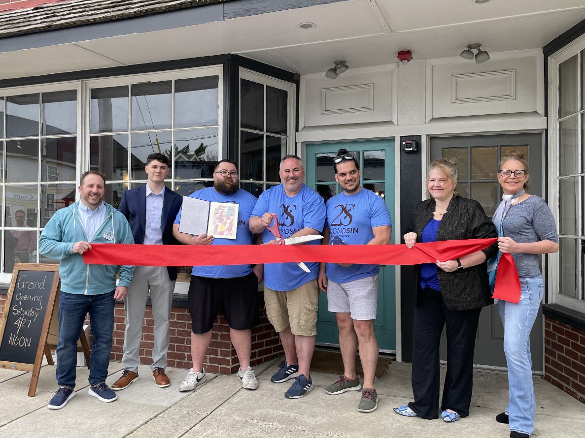 Newtown business leaders join the owners of Second Sin in cutting the ribbon on the new Taproom.
