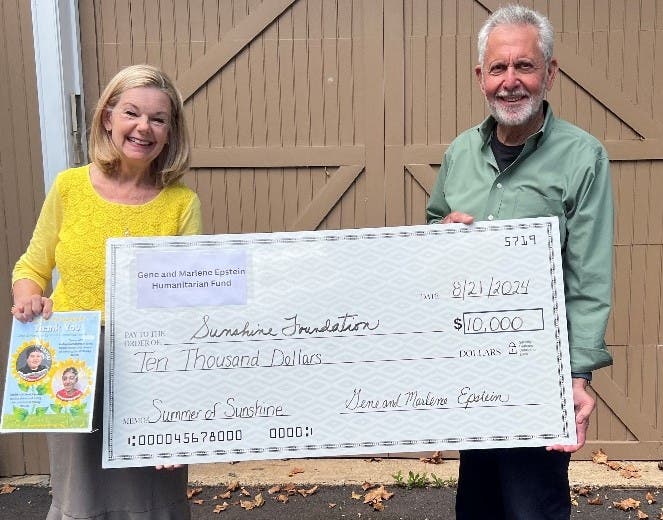 Gene Epstein presents the Sunshine Foundation with a $10,000 donation. Accepting is Sunshine Foundation President Kate Sample.