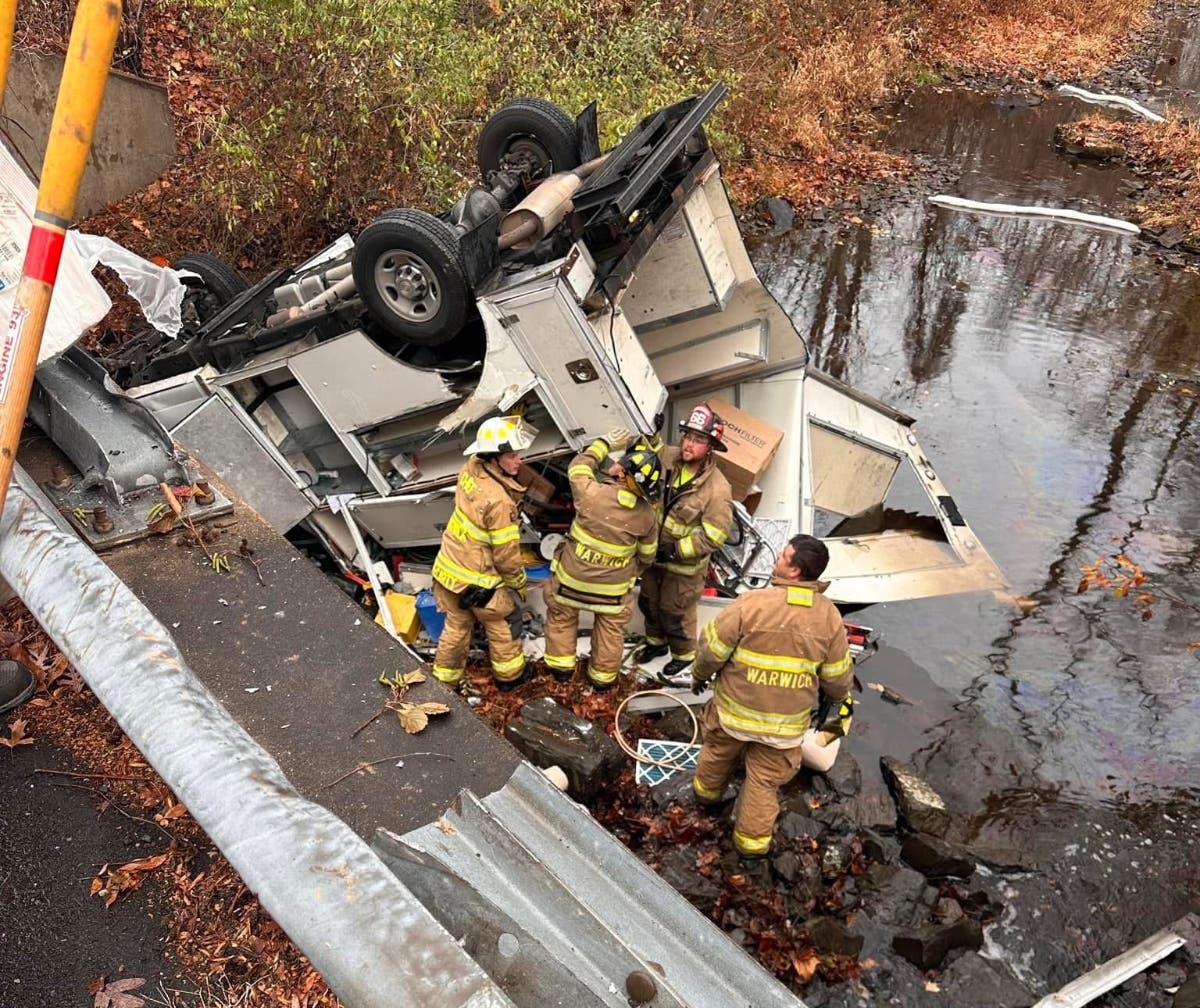 Firefighters work to secure vehicle hazards at the crash site.