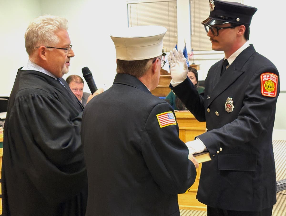 Firefighter Sam Fleischer is sworn in during a ceremony at the Newtown Township Building Wednesday night.