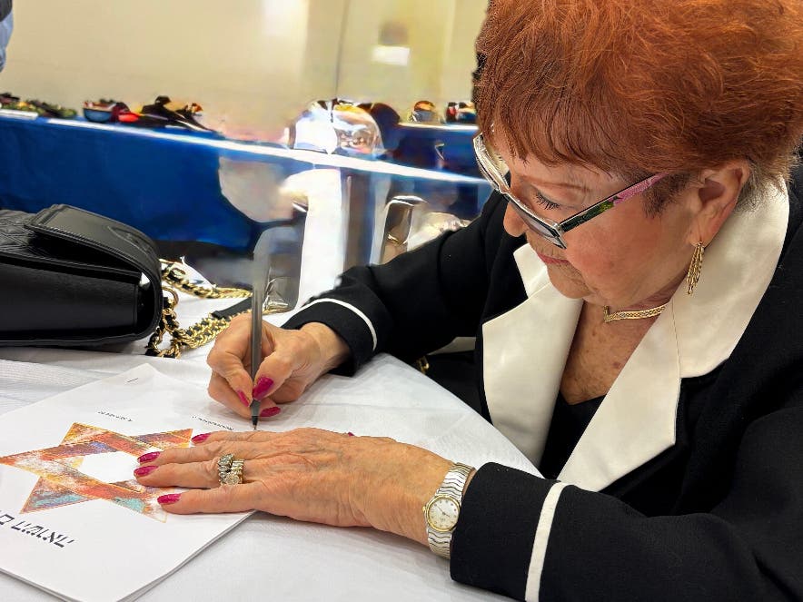 95-year-old Holocaust survivor Sarah Meller signs copies of her memoir at Temple Judea. 
