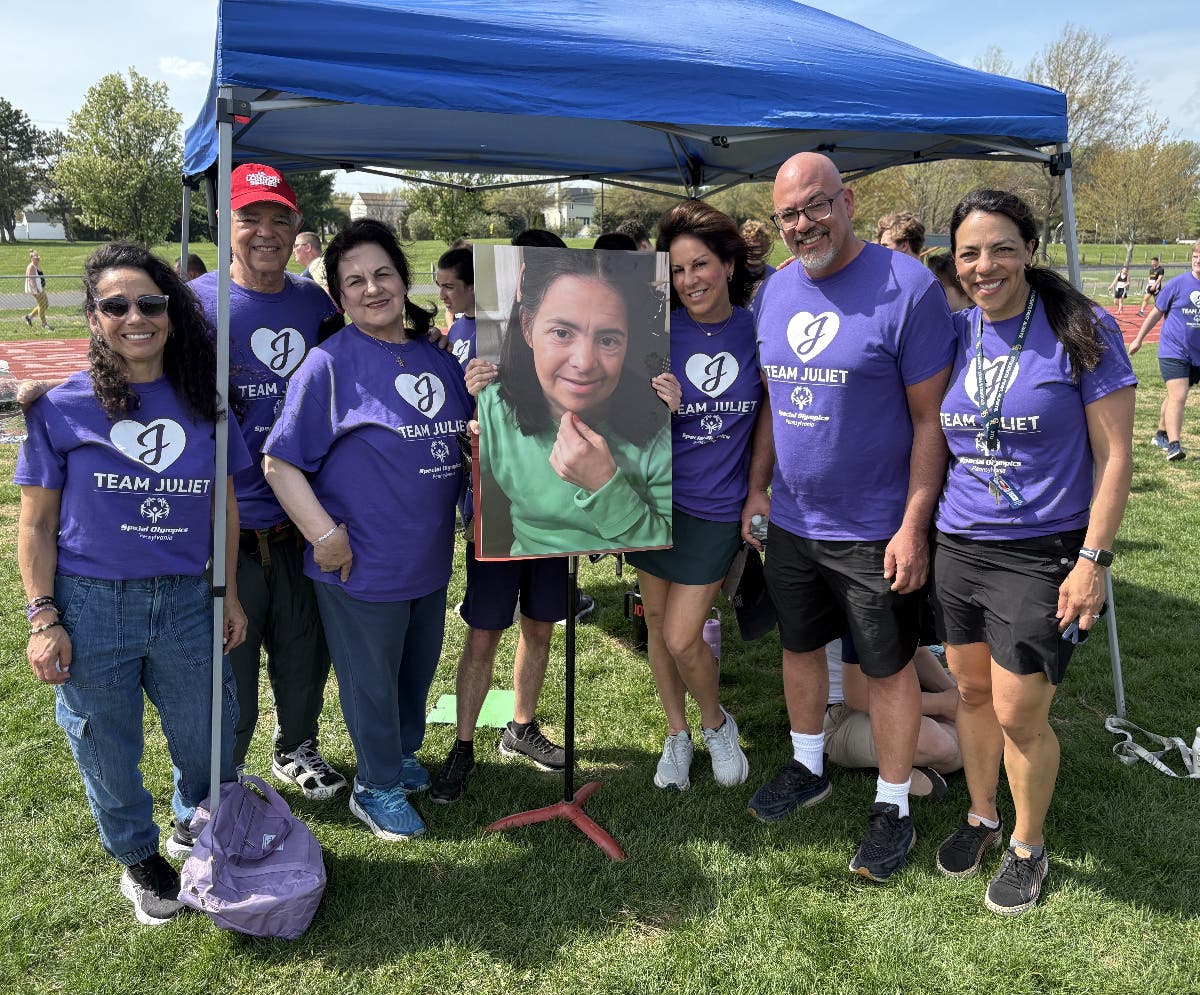 Coach Meg Russell, right, and members of her family hold a photo of Juliet Primola, who passed away in February.