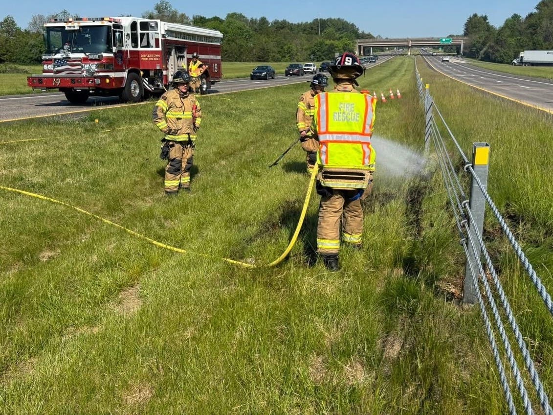 Doylestown firefighters wet down the median after extinguishing a brush fire.