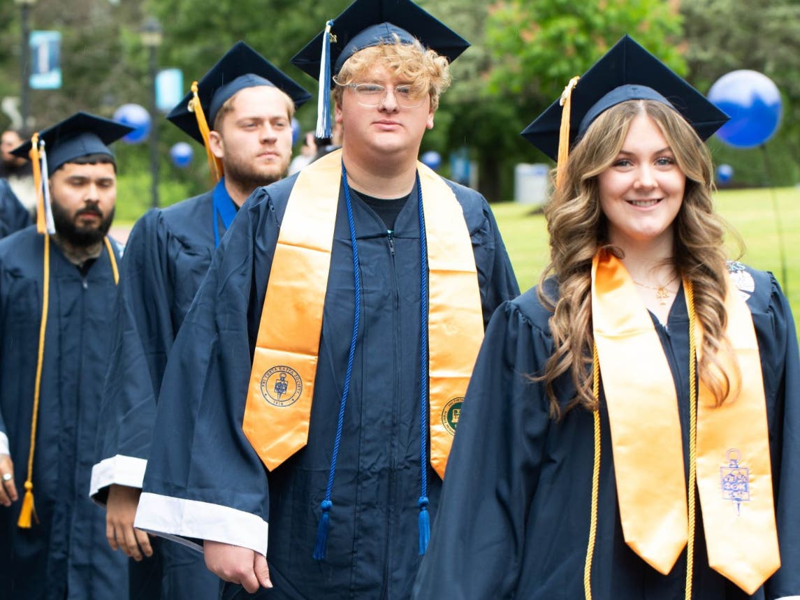 Heather McMenamin (right), a PreK-4 Early Education major, processes into Bucks County Community College’s 60th Commencement. The Newtown resident graduated from the college’s honors program and was named to the All-Pennsylvania Academic Team.