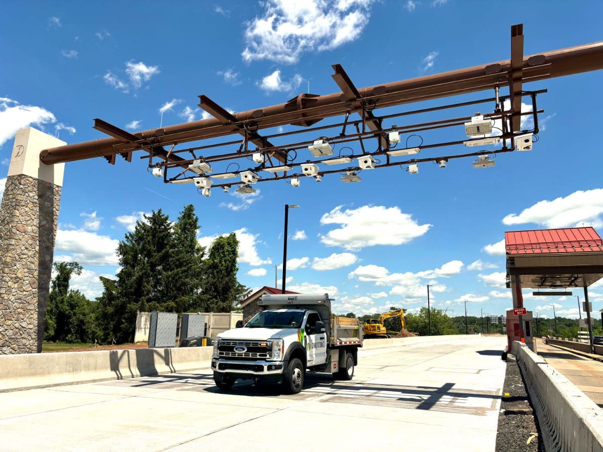 A truck passes underneath the new gantry during a test of the new tolling system.