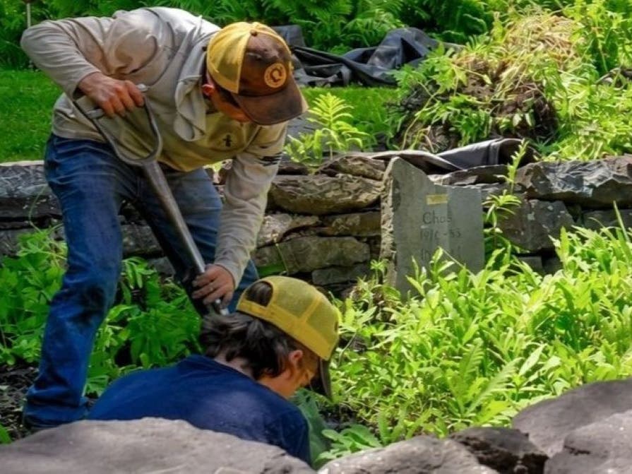 Workers with Garden Girl working to restore the cemetery.