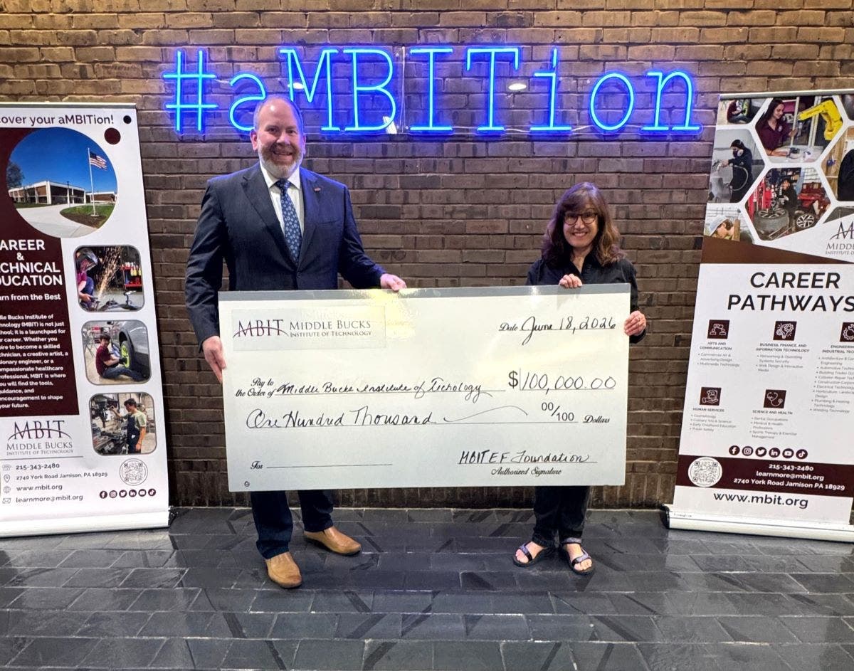 MBIT Administrative Director Mark Covelle accepts a ceremonial check from Jan Solkov, chairperson of the MBIT Education Foundation.