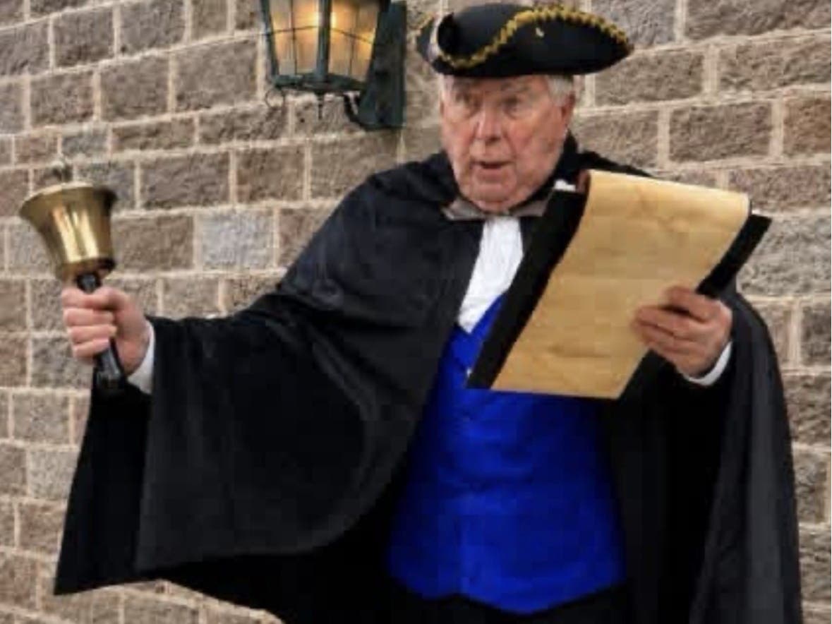 A Town Crier announces the Fourth of July town-wide bell ringing.