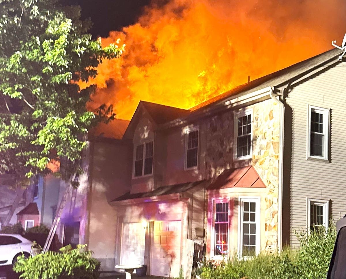 Orange flames can be seen behind the two-story townhome.
