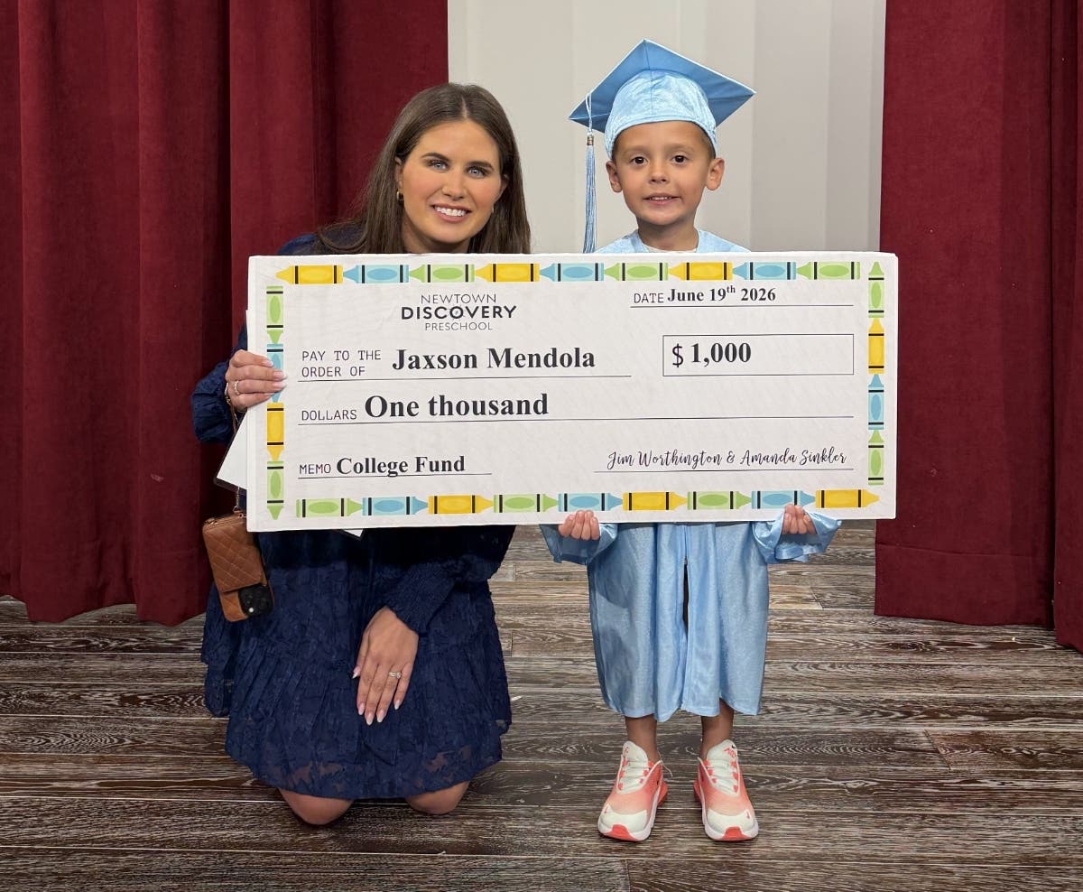 Amanda Sinkler, CEO and Founder of Discovery Preschools, presents one of the first checks to Jaxson Mendola.