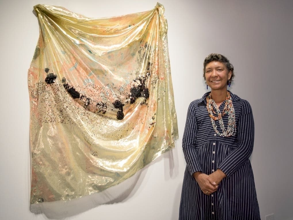 Artist Duwenavue Santé Johnson stands beside her textile work featured in “Visions of
America” at Bucks County Community College's Hicks Art Center Gallery. Johnson will
lead a hand sewing workshop on Saturday, July 25, at the gallery.