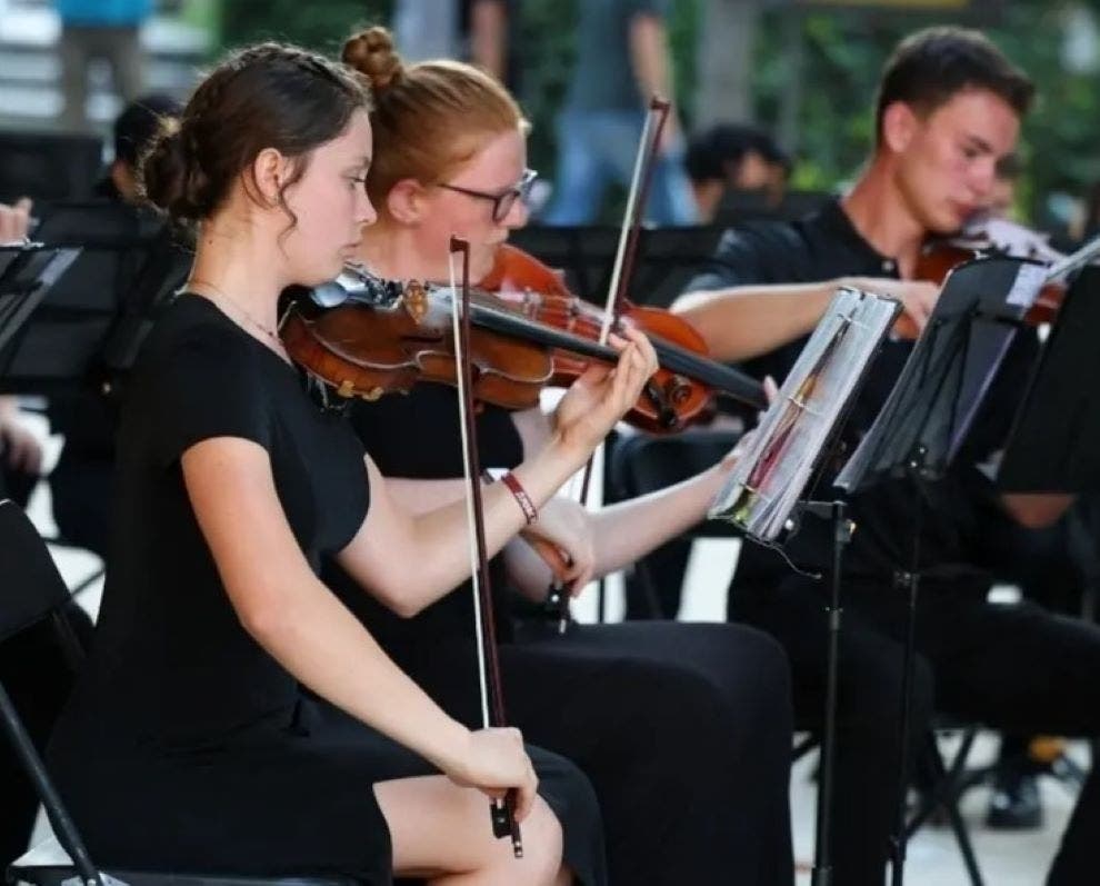 The violin section tunes up for Sunday's performance.