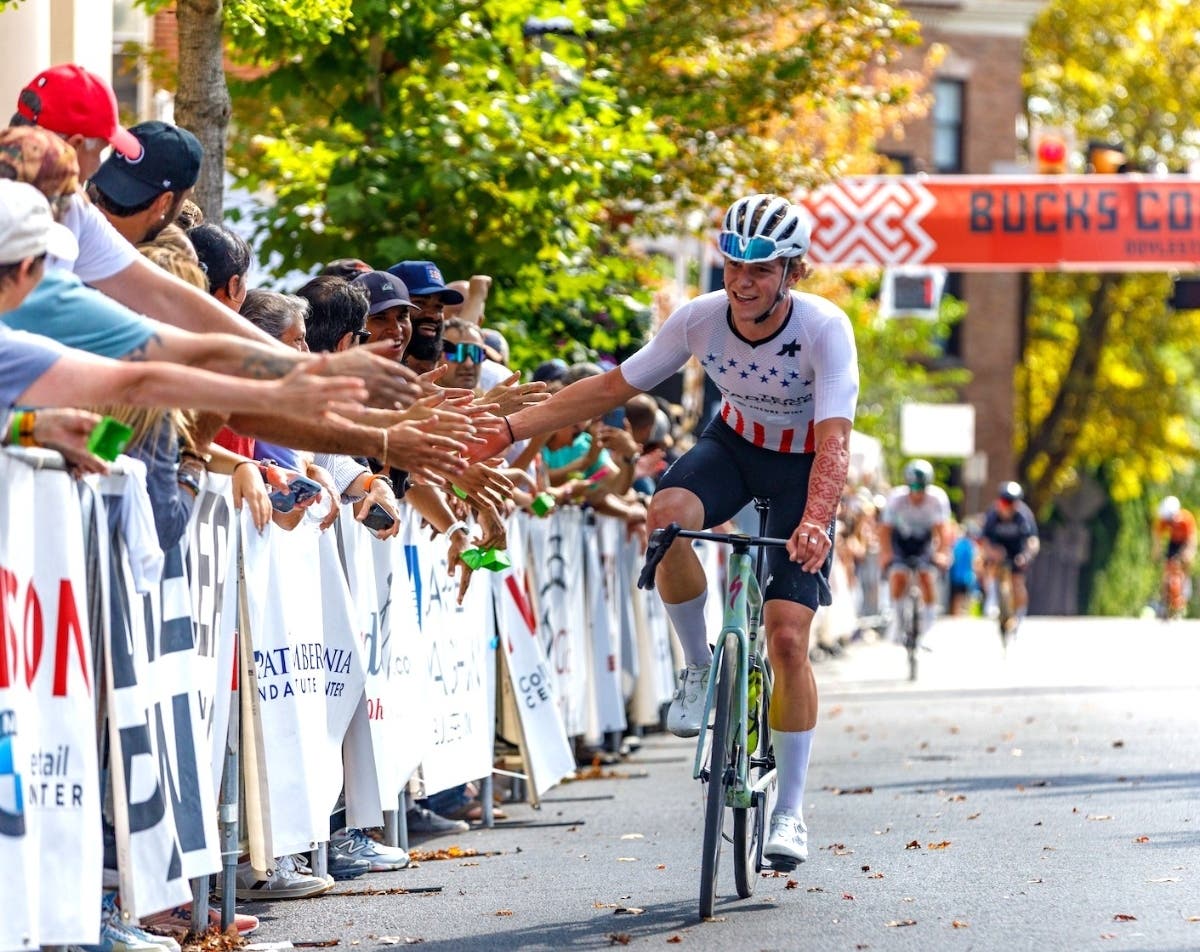 2025 U23 National Champion, Luke Fetzer of Cadence Cyclery pb Encore Wire, greets fans along the finish line.