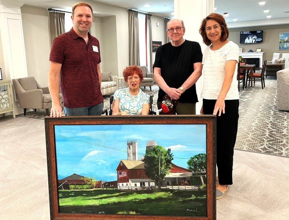 The Birches at New Hope Executive Director Justin Mason, left, accepts the painting from Elaine Gibbs and artist Patrick Walsh. They are joined by The Birches at New Hope Marketing Director Jennifer Doone, right.