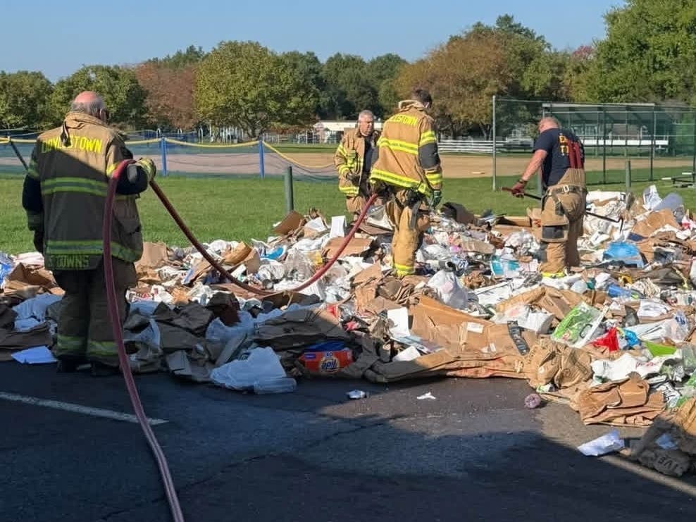 Firefighters search through the trash looking for anything still on fire.