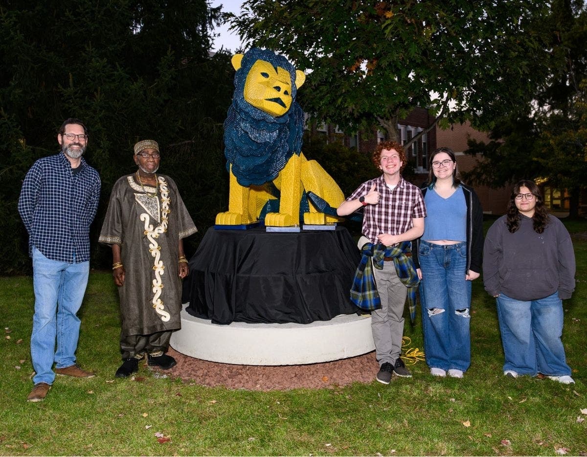 New Hope-Solebury art teacher Mark Mannion, left, with sculptor Mike Gyampo and students at the unveiling of Lionardo.