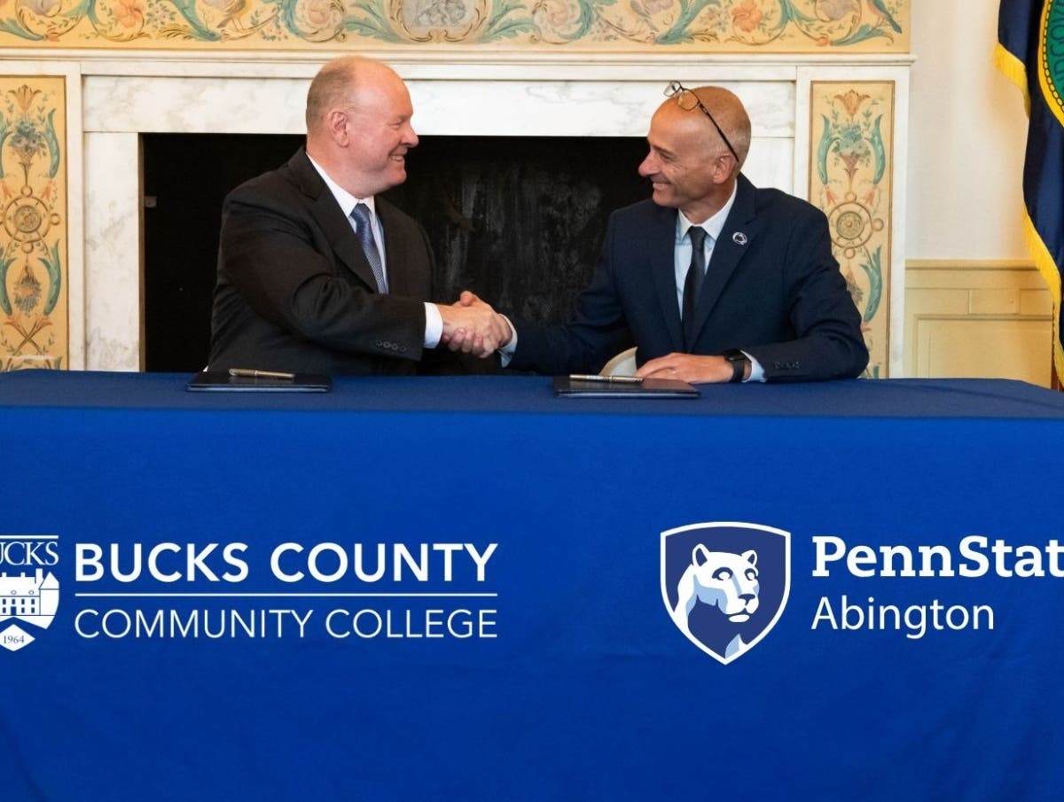 Bucks County Community College President &amp; CEO Patrick M. Jones, Ph.D., (left) and
Penn State Abington Chancellor Gary Liguori, Ph.D., (right) mark the signing of a new
Honors-to-Honors transfer agreement with a handshake.
