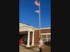 SMJC Member Barry Schwoerer in front of Kenneth W. Culbert Elementary school with flag and flag pole 