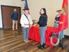 Mark Sink (Oldest Marine) presented Caitlen Gedney-Ray (Youngest Marine) the 2nd piece of cake.  In background to left: Captain William Gazes, to right: Shannon Combs-Barrett