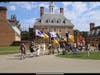Honor Guard marching on with the SAR 250 flag and chapter flags in front of the Governor's Palace at Williamsburg