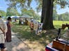 three youngsters with the face cutouts of Rev War era soldiers and ladies.  Liberty Bell to far right