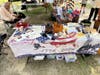 Games and crafts of the Revolution: L-R:  Making corn husk dolls, writing with a quill pen, feather darts, Whirligigs, cup and ball, making rev war cartridges using inert materials
