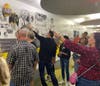 Andrew High School alumni from the early ‘80s look for classmates they recognize on the Decades Wall as part of their reunion tour.