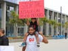 Princeton sits atop his father Dante Bradford's shoulders as food truck vendors protest outside of Long Beach City Hall.
