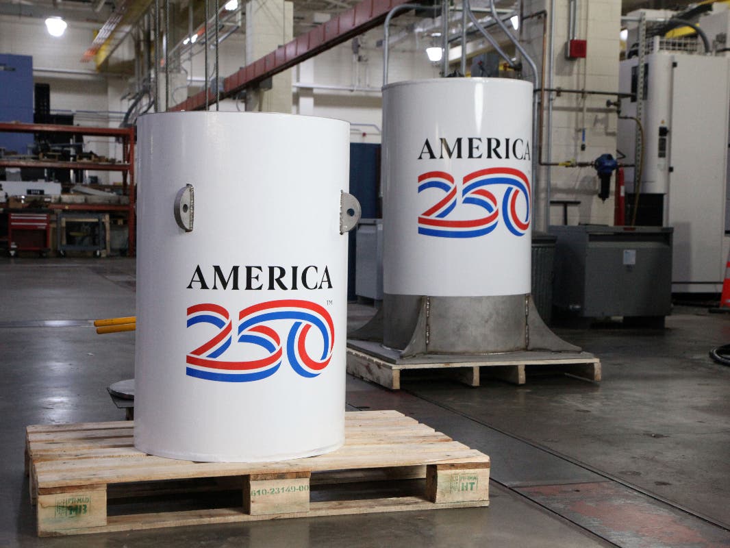The America250 time capsule, left, and the bell jar that will fit on top of it, shown here in the machine shop where they were created at the National Institute of Standards and Technology (NIST) in Gaithersburg, Md.