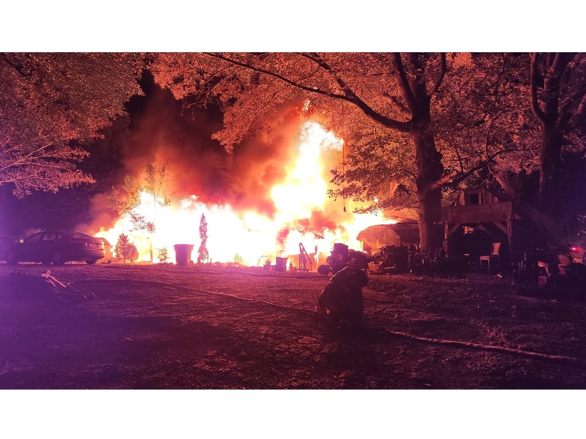 A massive fire burns a home around 1 a.m. Monday at Bells Ferry Road in Cherokee County. A man has bee arrested on arson charges in connection with the fire.